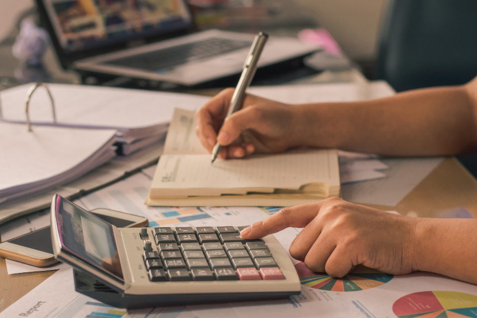 Agenda, calculadora y anotaciones sobre una mesa de trabajo